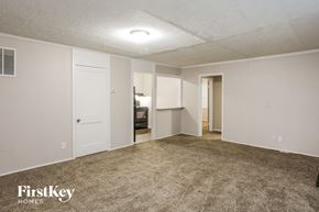 Kansas City house for rent - an empty living room with carpet and white walls
