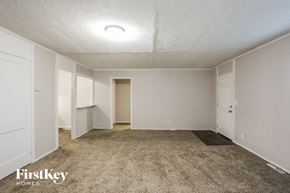 Kansas City house for rent - an empty living room with carpet and white walls