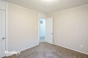 Kansas City house for rent - a bedroom with white walls and carpet and a door to a closet