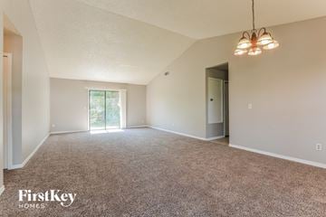 Deltona house for rent - a spacious living room with carpet and a door to the kitchen