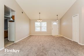 Deltona house for rent - a spacious living room with carpet and a door to the kitchen