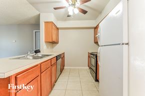 Deltona house for rent - a kitchen with wooden cabinets and a sink and a refrigerator