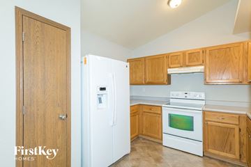 Wentzville house for rent - A kitchen with wooden cabinets and a white fridge.