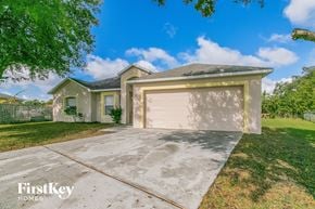 Poinciana house for rent - a beige house with a garage with a concrete driveway