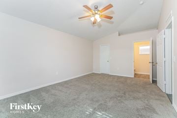 Poinciana house for rent - a spacious living room with carpet and a ceiling fan