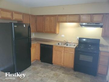 Cincinnati house for rent - A kitchen with wooden cabinets and black appliances.