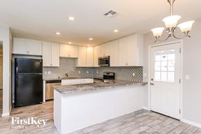 Chandler house for rent - a kitchen with white cabinets and a black refrigerator