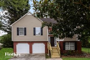 Austell house for rent - A house with a garage and a tree in front of it.