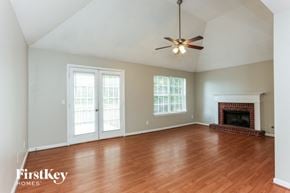 Austell house for rent - A room with a fireplace and a ceiling fan.