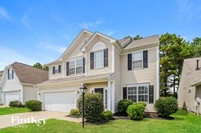 Huntersville house for rent - A house with a garage and a tree in front of it.