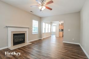 Huntersville house for rent - A spacious room with a fireplace and wooden flooring.