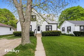 Winthrop Harbor house for rent - a white house with black doors and a sidewalk in front of a tree