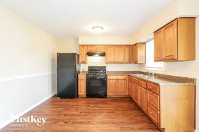 Winthrop Harbor house for rent - a kitchen with wooden cabinets and a black stove and refrigerator