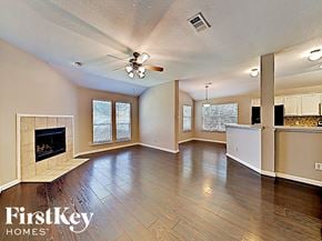 Anna house for rent - an empty living room with a fireplace and a ceiling fan