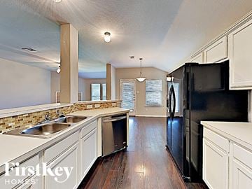 Anna house for rent - a large kitchen with stainless steel appliances and white cabinets