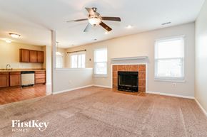 Bargersville house for rent - an empty living room with a fireplace and a ceiling fan