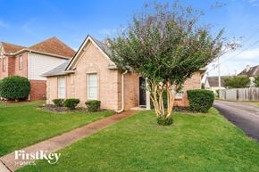 Cordova house for rent - A brick house with a tree in front of it.