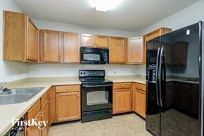 Monroe house for rent - a kitchen with black appliances and wooden cabinets