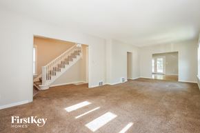Aurora house for rent - A spacious room with a staircase leading to the second floor.