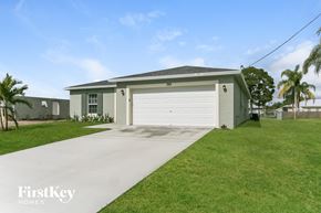 Port St. Lucie house for rent - a small green house with a white garage door