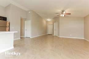 Port St. Lucie house for rent - a spacious living room with tile flooring and a ceiling fan