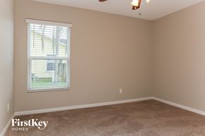 Port St. Lucie house for rent - a bedroom with a carpeted floor and a window
