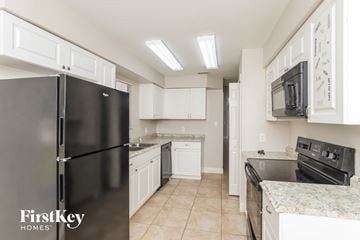 Rockledge house for rent - a kitchen with stainless steel appliances and white cabinets