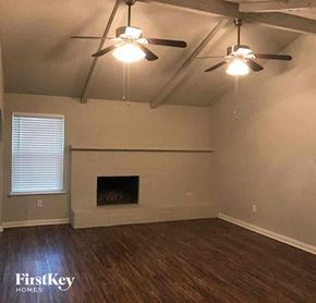 Burleson house for rent - A room with a fireplace and a ceiling fan.