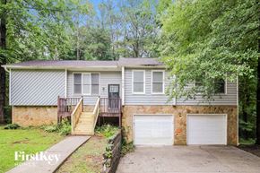 Lithonia house for rent - a home with two garage doors and a stone wall