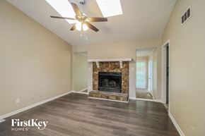 Lithonia house for rent - an empty living room with a fireplace and a ceiling fan
