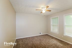 Lithonia house for rent - a bedroom with carpet and a ceiling fan
