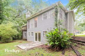 Lithonia house for rent - a gray house with white siding and a yard with trees