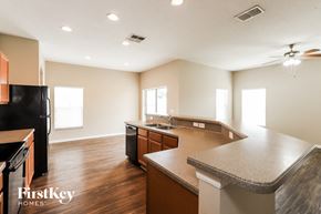 Seffner house for rent - a kitchen with an island and a black refrigerator