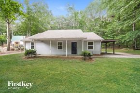 Senoia house for rent - a small white house with a lawn and trees