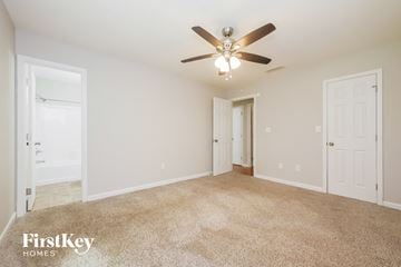 Senoia house for rent - a spacious living room with carpet and a ceiling fan