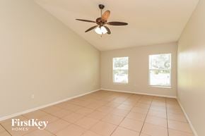 Poinciana house for rent - an empty living room with a ceiling fan and a tiled floor