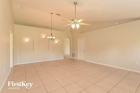 Poinciana house for rent - a spacious living room with a ceiling fan and a tiled floor