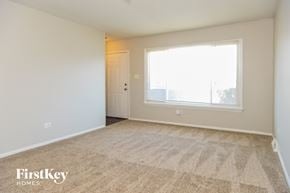 Calumet City house for rent - an empty living room with carpet and a large window