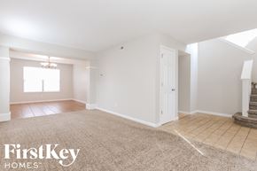 Brownsburg house for rent - A spacious room with a carpeted floor and a staircase on the right side.