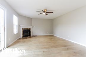 Brownsburg house for rent - A room with a fireplace and a ceiling fan.