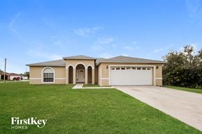 Kissimmee house for rent - a beige house with a garage and a lawn