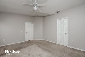 Kissimmee house for rent - a bedroom with two doors and a ceiling fan