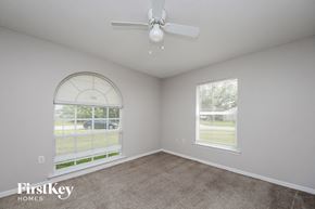 Kissimmee house for rent - a living room with a ceiling fan and a window
