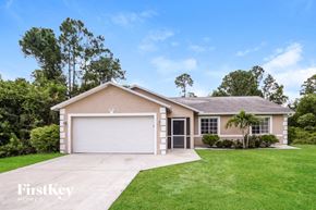 Lehigh Acres house for rent - a beige house with a lawn and a garage door