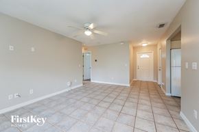 Lehigh Acres house for rent - a spacious living room with tile flooring and a ceiling fan