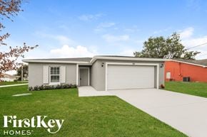 Port St. Lucie house for rent - a white house with a garage door and a lawn