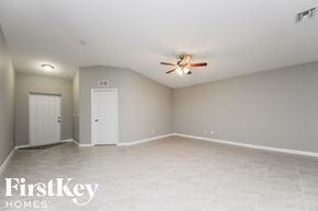 Port St. Lucie house for rent - the spacious living room with tile flooring and a ceiling fan