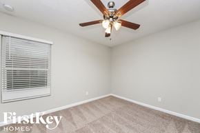 Port St. Lucie house for rent - a bedroom with a ceiling fan and a window