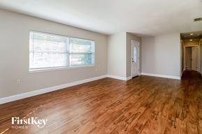Orlando house for rent - the living room and dining room with wood flooring and a large window