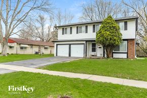 University Park house for rent - a white and brick house with a garage and a lawn